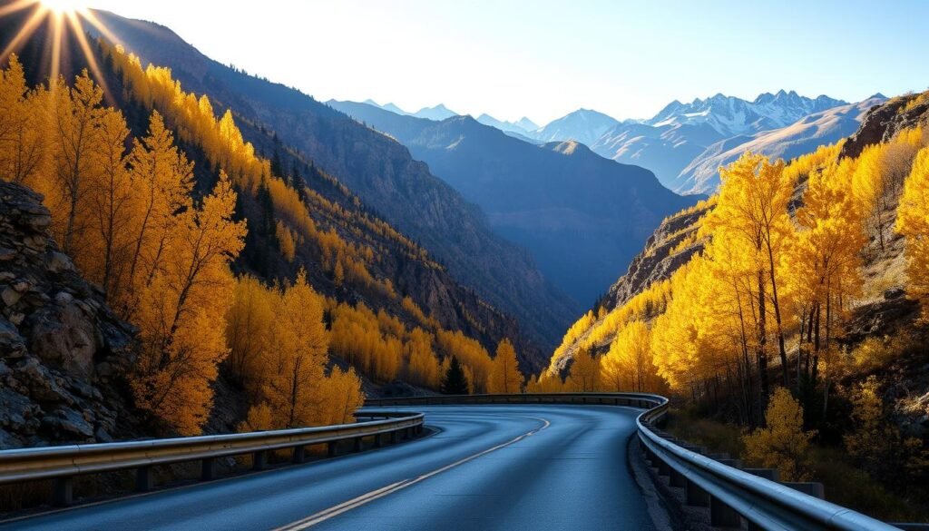 A winding ribbon of road snakes through the rugged San Juan Mountains, flanked by towering peaks draped in a tapestry of autumn colors. Sunlight filters through the golden leaves of aspen trees, casting a warm glow over the scene. In the foreground, the iconic guardrails of the Million Dollar Highway hug the curves, inviting the viewer to embark on an unforgettable journey. The middle ground reveals sweeping vistas of the Uncompahgre Gorge, its sheer cliffs a dramatic contrast to the vibrant foliage. In the distance, snow-capped summits rise against a clear, azure sky, completing the breathtaking panorama. Capture the essence of Colorado's stunning fall foliage road trip, a visual feast for the senses.